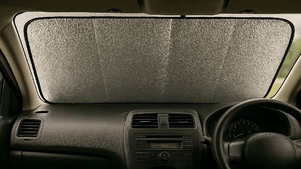 車のフロントガラスにアルミ製サンシェードを装着しているイメージ。