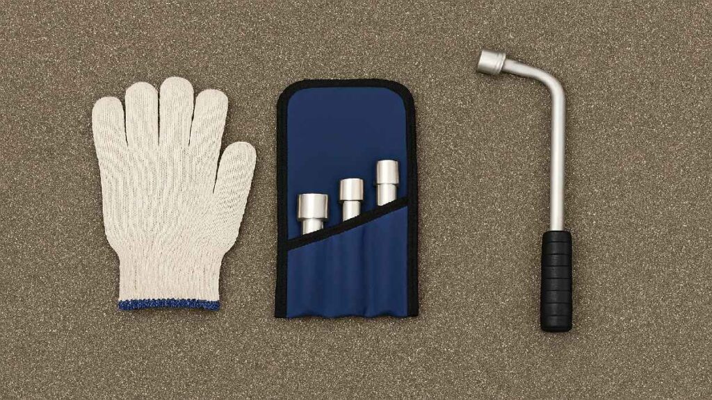 ホイールレンチ、軍手、ソケットセットを左右バランスよく並べたタイヤ交換準備の写真風イメージ