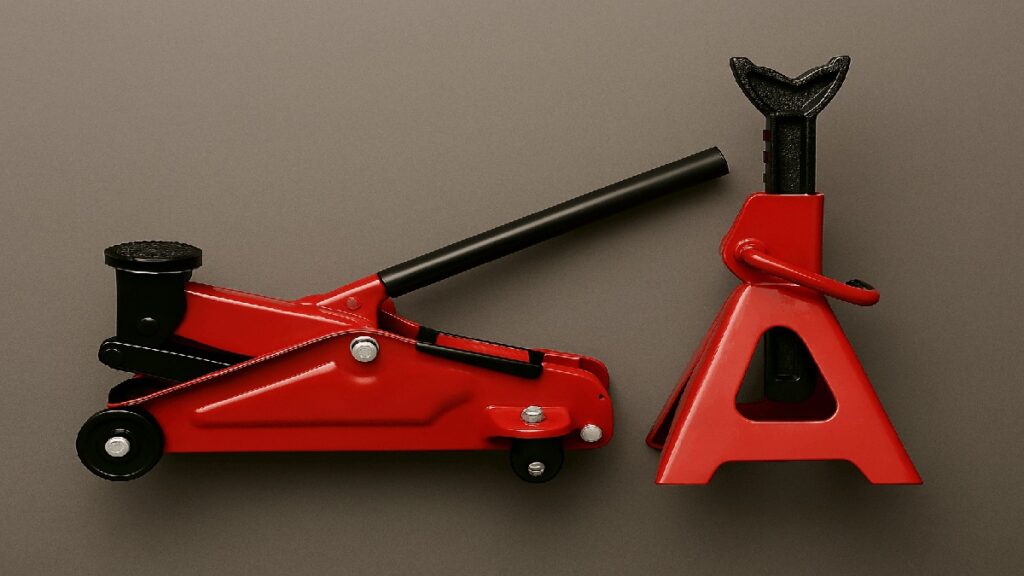 赤いジャッキとジャッキスタンドのセットがグレー背景に並ぶ写真。黒のサドル、ハンドル、ラチェット部分が特徴。