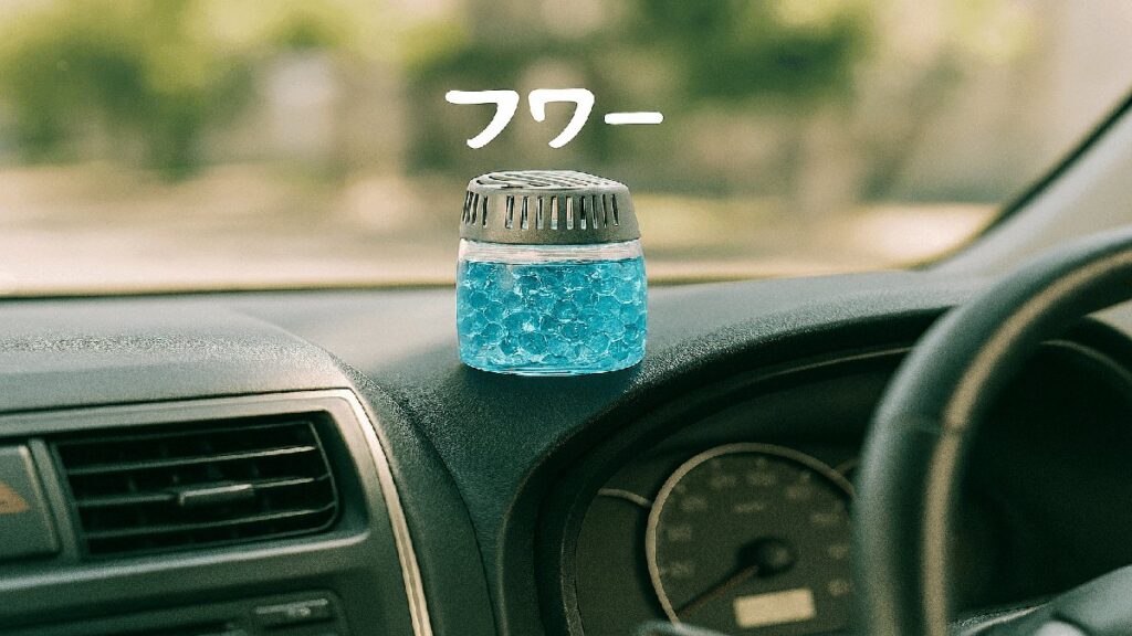 ダッシュボードにジェルタイプ芳香剤が置かれ、右ハンドル車の運転席の一部が映っている車内の風景