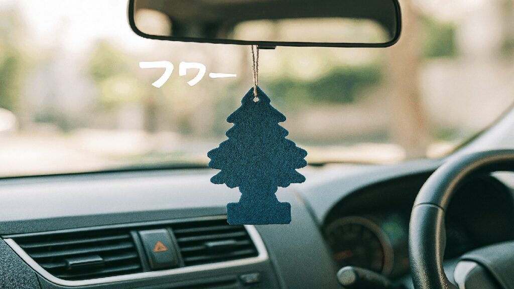 吊り下げタイプの芳香剤がミラーにぶら下がっている車内の風景、右ハンドル車の運転席からの視点